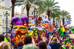 A festive parade during the New Orleans Mardi Gras celebration, featuring elaborate floats, costumed riders, and a lively crowd.