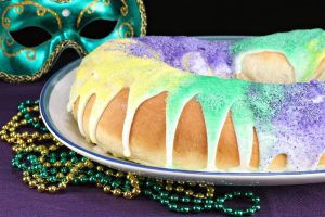 A traditional King Cake, a ring-shaped pastry closely associated with Mardi Gras celebrations in New Orleans.