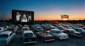A classic American drive-in theater scene featuring a film titled "Starlight Drive-In