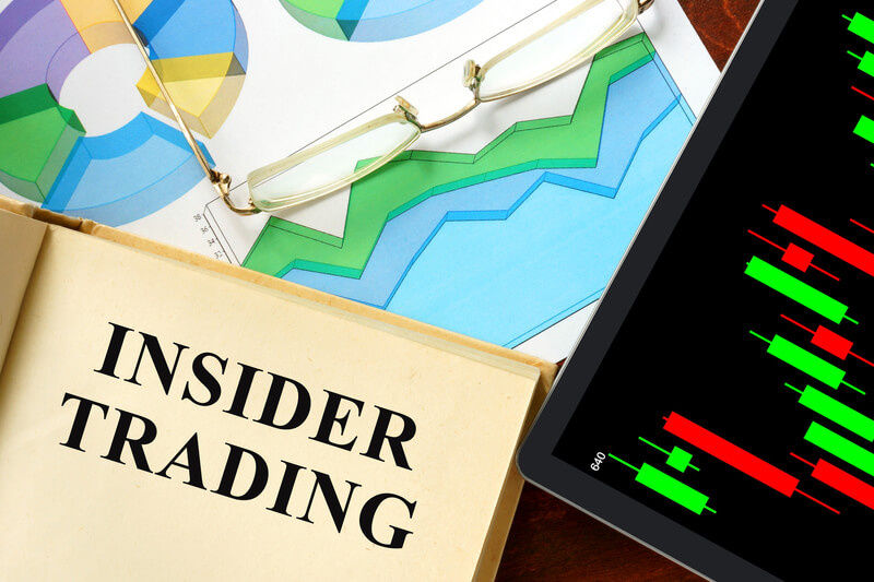 Words insider trading written on a book. Business concept.