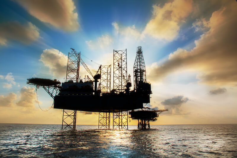 Silhouette,Offshore oil and rig platform in sunset or sunrise time. Construction of production process in the sea. Power energy of the world.
