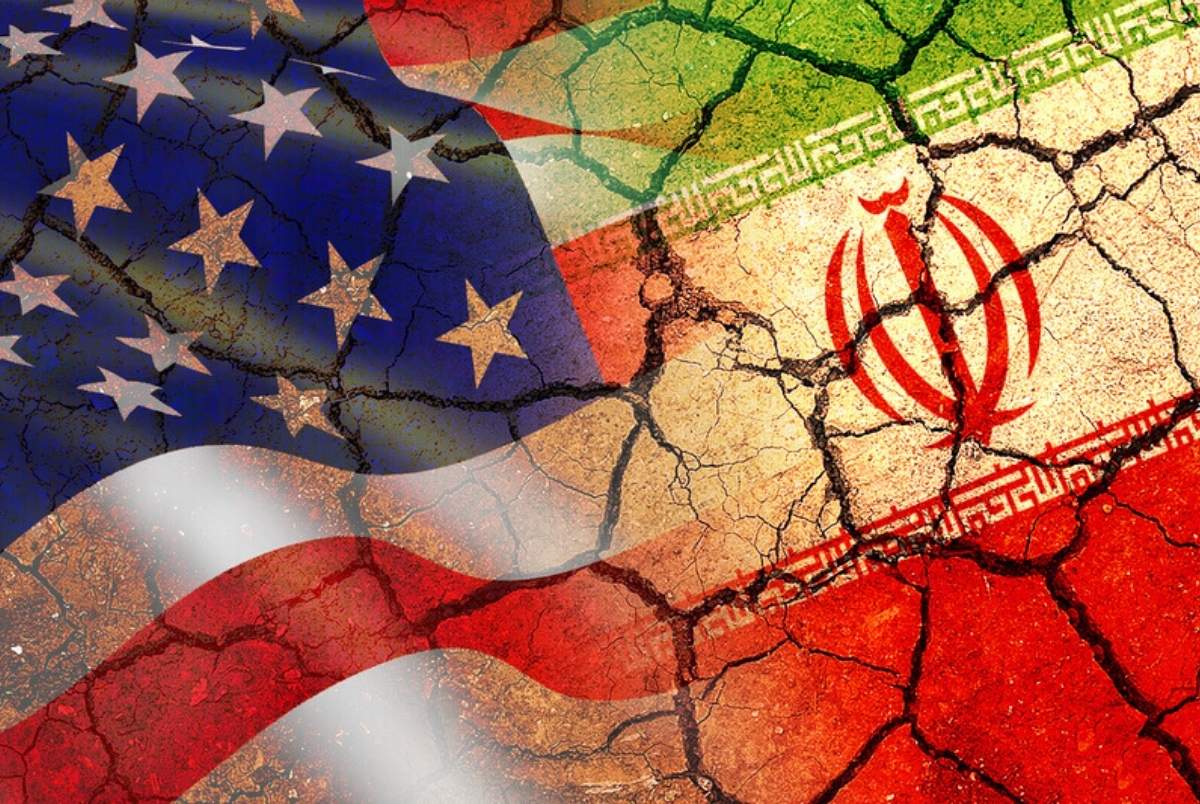 Concept of Conflict between USA and Iran war / US America and Iran flags on split up dried cracked earth soil ground