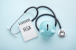 Health saving account, hsa concept on blue background. Health saving account, hsa concept, piggy bank with stethoscope on pastel blue background, top view