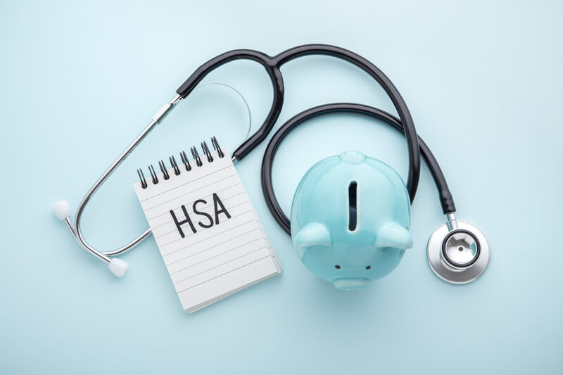 Health saving account, hsa concept on blue background. Health saving account, hsa concept, piggy bank with stethoscope on pastel blue background, top view