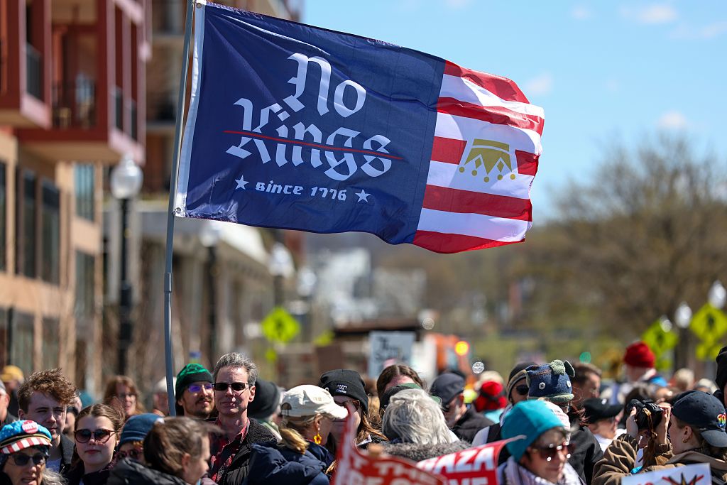 WASHINGTON, DC - MARCH 28: Protesters hold a "No Kings" flag as they gather in Southeast Area and take part in rally and march on March 28, 2026 in Washington, DC. This is the third nationwide "No Kings" protest held against the Trump administration. (Photo by Tasos Katopodis/Getty Images)