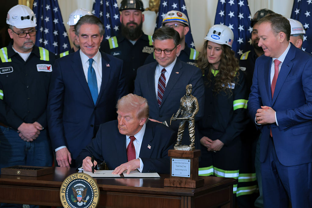 WASHINGTON, DC - FEBRUARY 11: U.S. President Donald Trump signs an executive order as he is joined U.S. Secretary of the Interior Doug Burgum (L), Speaker of the House Mike Johnson (R-LA), and U.S. Environmental Protection Agency Administrator Lee Zeldin (R) during an event on the use of coal in the East Room of the White House on February 11, 2026 in Washington, DC. The lobby group Washington Coal Club awarded Trump the "Undisputed Champion of Coal" award. Trump is also expected to sign an executive order directing the Defense Department to buy electricity from coal-fired power plants. (Photo by Anna Moneymaker/Getty Images)