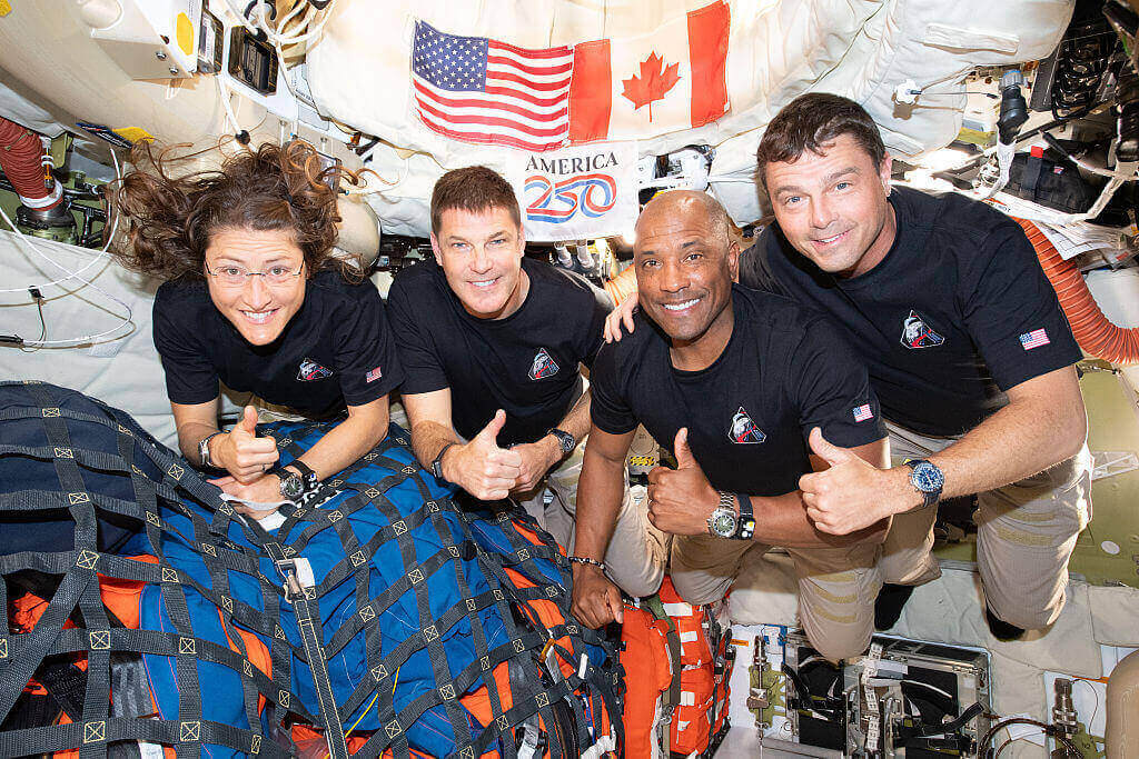 In this handout image provided by NASA, The Artemis II crew – (from left) Mission Specialist Christina Koch, Mission Specialist Jeremy Hansen, Pilot Victor Glover, and Commander Reid Wiseman – pause for a group photo inside the Orion spacecraft on their way home.