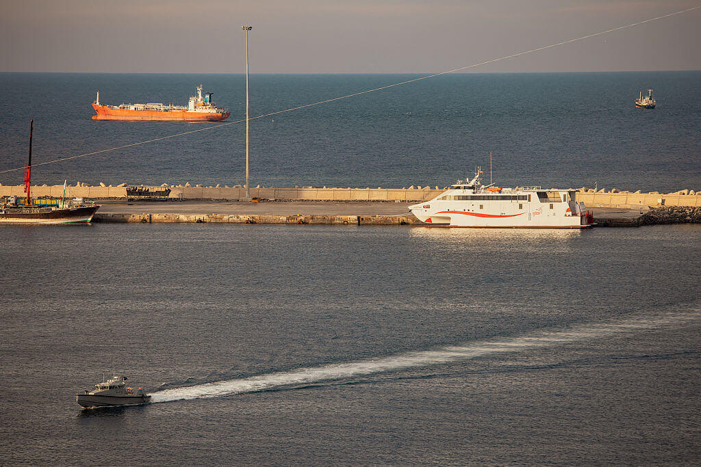A police speed boat patrols the port as oil tankers and high speed crafts sit anchored at Muscat Anchorage near the Strait of Hormuz on March 30, 2026 in Muscat, Oman.