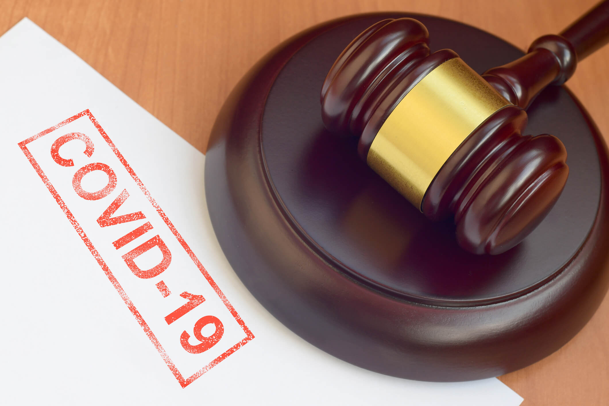 Justice mallet and blank document with Covid-19 red stamp close up