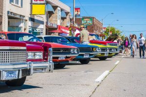 A classic car show taking place on a sunny day in downtown Ontario.