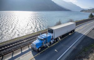 A refrigerated semi-trailer truck, commonly referred to as a "reefer" truck, designed for transporting perishable goods.