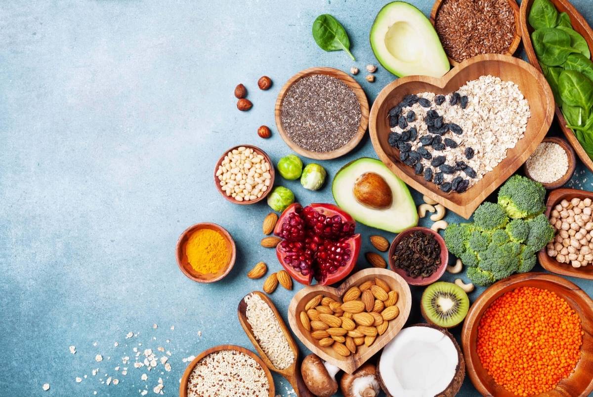 Healthy food background from fruits, vegetables, cereal, nuts and superfood. Dietary and balanced vegetarian eating products on kitchen table top view
