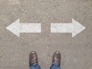 Standing at the crossroad making decision which way to go - easy or hard
