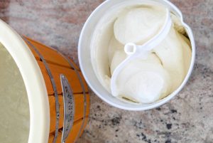 Home made ice cream maker on backdoor porch. Appliance that uses an ice bath and rock salt with a churn to make ice cream