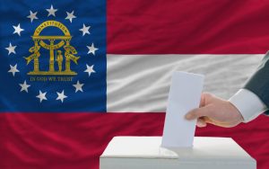 Man voting on elections in georgia. Man putting ballot in a box during elections in georgia in fornt of flag