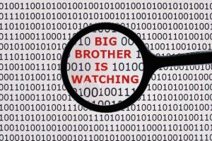 Internet security concept the words big brother is watching on a digital tablet screen with a magnifying glass