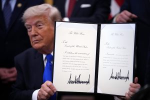 U.S. President Donald Trump holds up an executive order appointing Dr. Nicole Saphier as the new surgeon general during an event in the Oval Office of the White House on April 30, 2026 in Washington, DC.