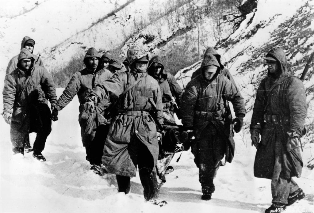 1950: Marines carry a wounded comrade through snow to a cleared airstrip for evacuation during the Korean War. (Photo by Keystone/Getty Images)