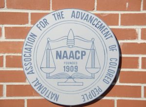 NAACP Founded in 1909 Logo on Brick, The mission of the National Association for the Advancement of Colored People is to ensure the political, educational, social, and economic equality of rights of all persons and to eliminate race-based discrimination.