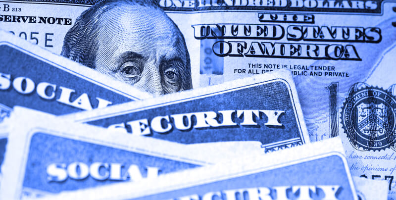 Social Security Cards with US One Hundred Dollar Bill $100. Several Social Security Cards on a US United States one hundred dollar bill $100 system of benefits for retired elderly people