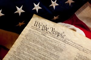 Preample of the constitution and american flag. The preamble of the Constitution of the United States of American on a flag