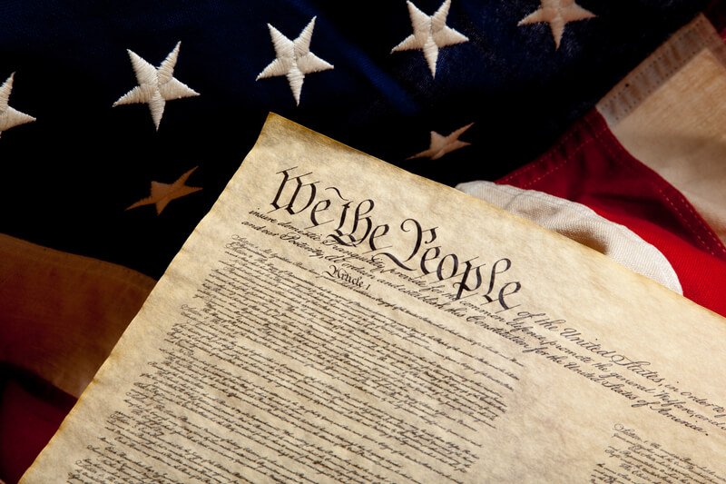 Preample of the constitution and american flag. The preamble of the Constitution of the United States of American on a flag