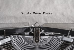 Words have power typed on old vintage aged typewriter with white blank sheet of paper.