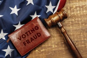 Voting fraud. Image of wooden judge hammer on USA flag top view