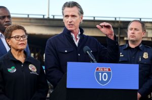 California Governor Gavin Newsom (C) speaks as Los Angeles Mayor Karen Bass (L) listens at a press conference near the closed I-10 elevated freeway following a large pallet fire, which occurred Saturday at a storage yard beneath the freeway, on November 13, 2023 in Los Angeles, California.