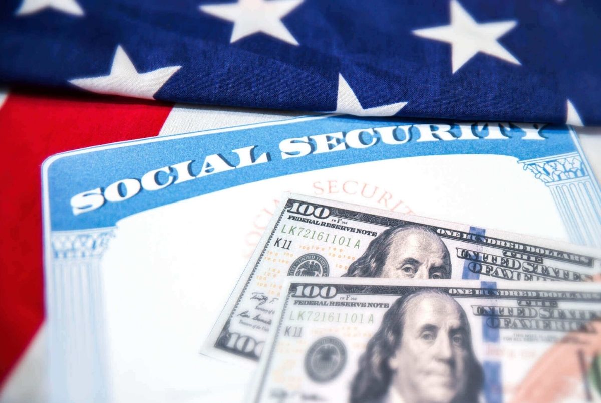 Social Security card is placed on the American flag, background. Social Security for old age people in USA concept backdrop.