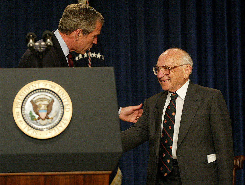 U.S. President George W. Bush greets Milton Friedman, recipient of the 1976 Nobel Prize for economic science, May 9, 2002 during a White House event in Washington, DC. Bush congratulated Friedman on his upcoming 90th birthday as well as his past achievements.