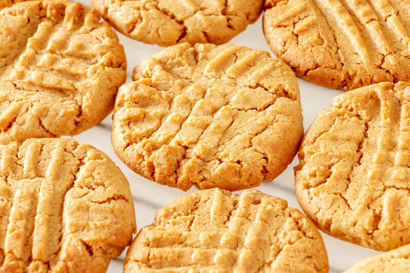 Close up delicious homemade peanut butter cookies on cooling rack. White background. Healthy snack concept. Macro photo.
