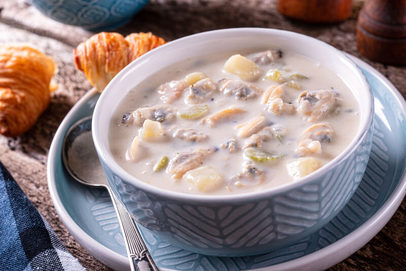 A bowl of delicious New England chowder with fresh clams, potato, celery and cream