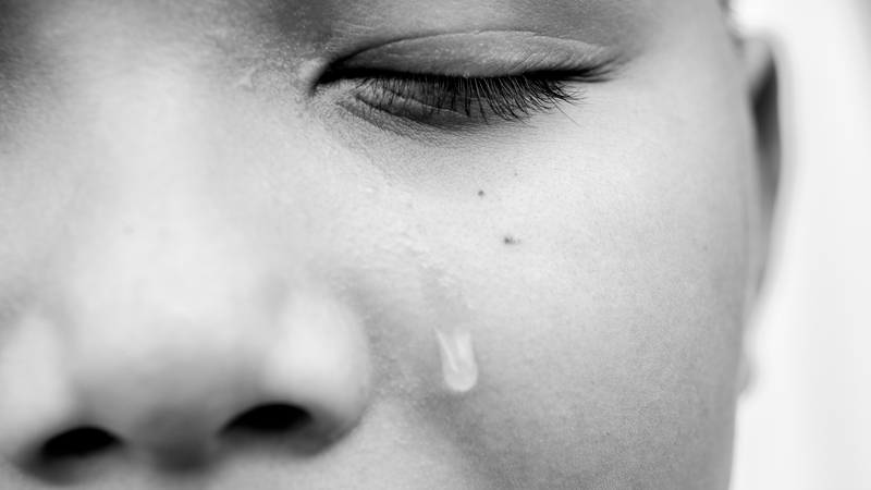 Young Asian boy crying. Young Asian boy sitting alone in the park crying, he looked scared and unsure of what he can do with his life, it is likely that he will be abused if he cannot get help and support