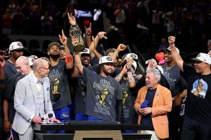 Jalen Brunson #11 of the New York Knicks lifts the Bill Russell NBA Finals Most Valuable Player Award trophy after defeating the San Antonio Spurs in Game Five of the 2026 NBA Finals at Frost Bank Center on June 13, 2026 in San Antonio, Texas.