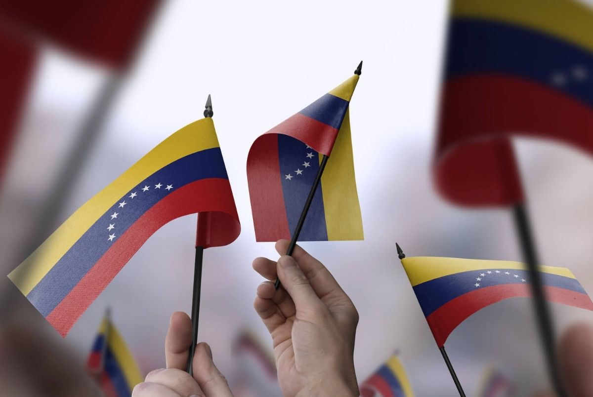 Venezuela flags in their hands on a blurred urban background. The photo illustration was created without the use of artificial intelligence, only using Photoshop.