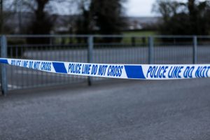 Police barrier tape at the scene of a crime. UK crimescene. Police cordon tape preventing access. Blue and white tape.