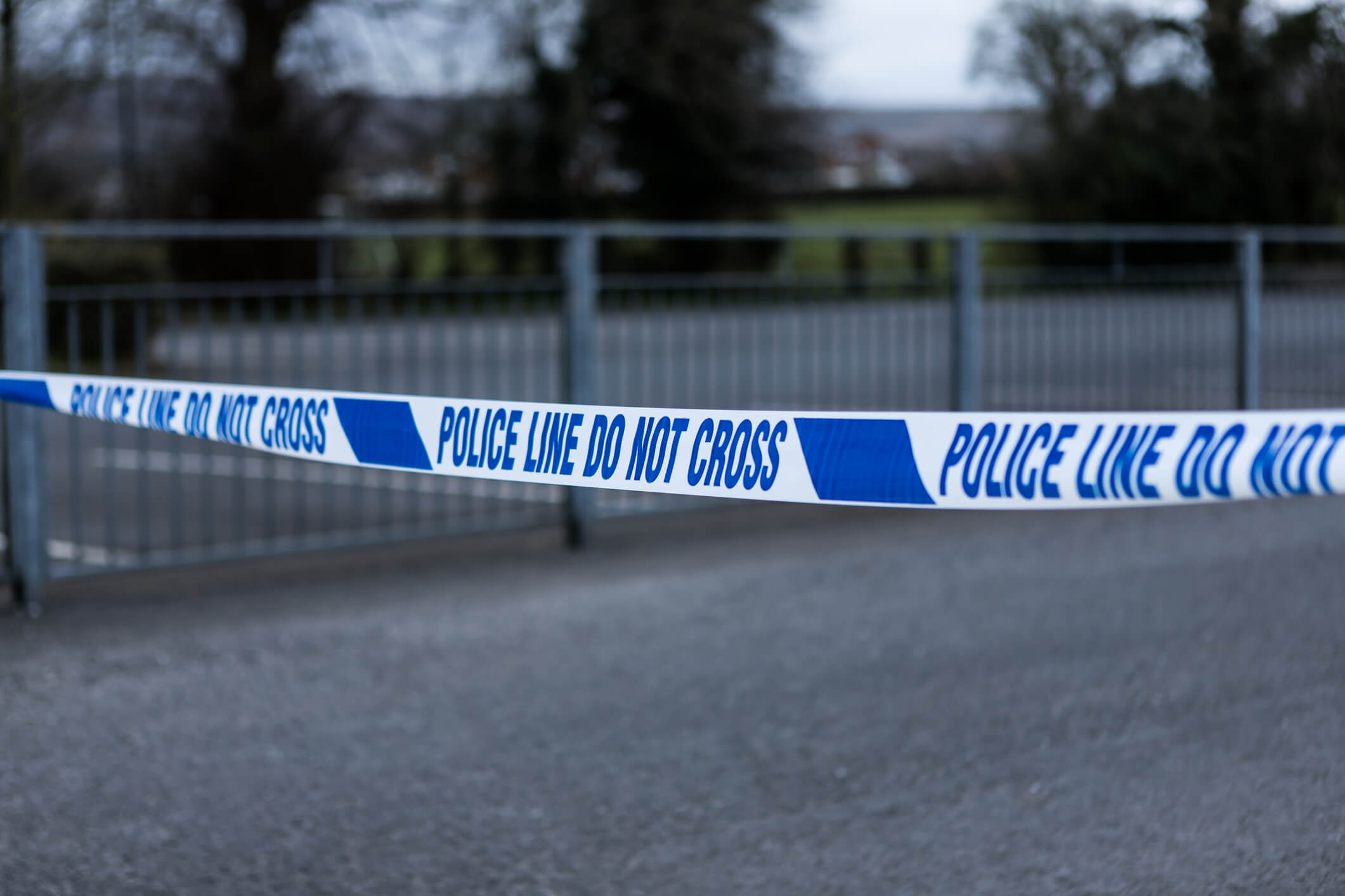 Police barrier tape at the scene of a crime. UK crimescene. Police cordon tape preventing access. Blue and white tape.