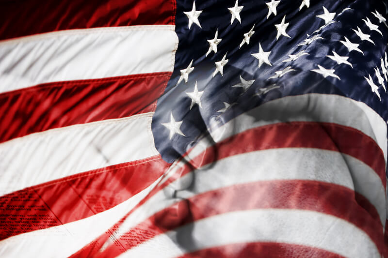 American Flag & Praying Hands (Blended Image). Blended image of an American Flag and praying hands over a Bible - represents faith and prayer for country, military, freedom, peace, and security.