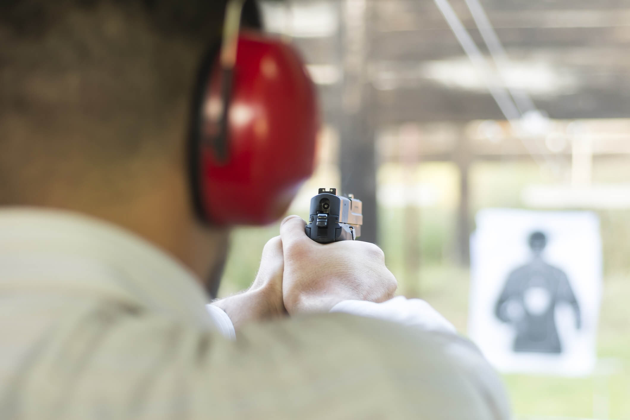 Shooting with Gun at Target in Shooting Range. Man Practicing Fire Black Pistol Shooting.