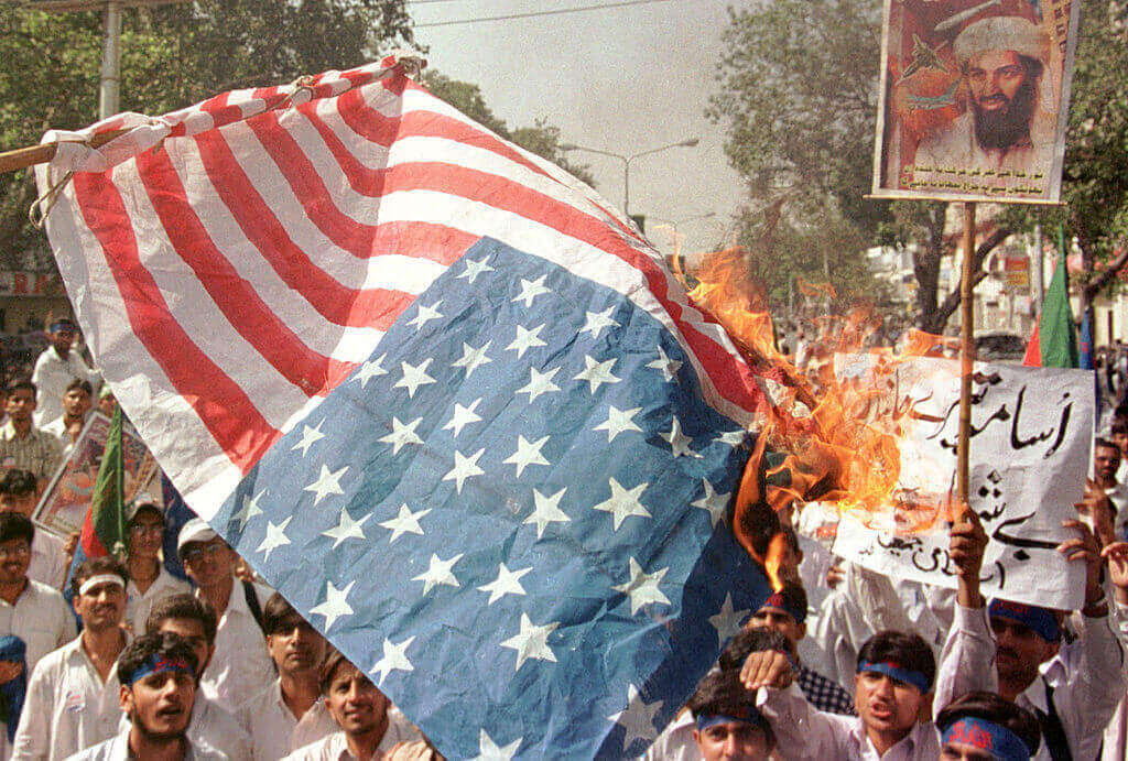 Pakistani supporters of Afghanistan's ruling Taliban Islamic militia, burn an American flag at a protest rally October 18, 2001 in Lahore, Pakistan.