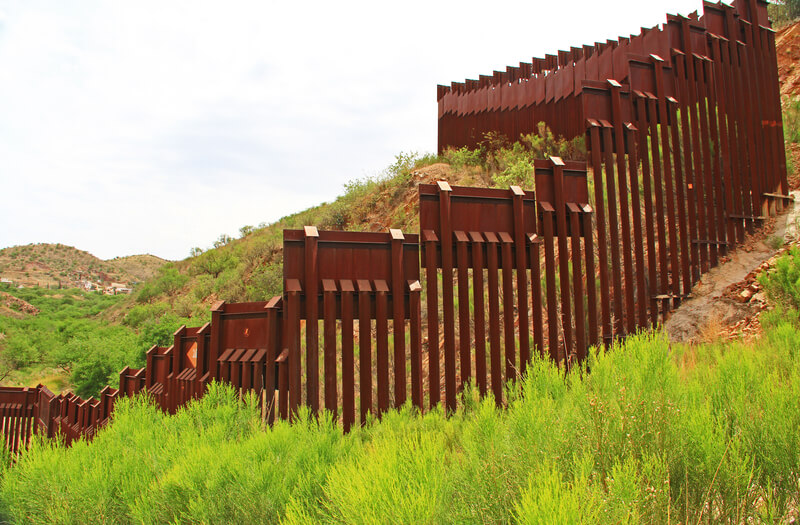 Border Fence Separating the US from Mexico Near Nogales, Arizona. Border Fence beside a road near Nogales, Arizona separating the United States from Mexico.