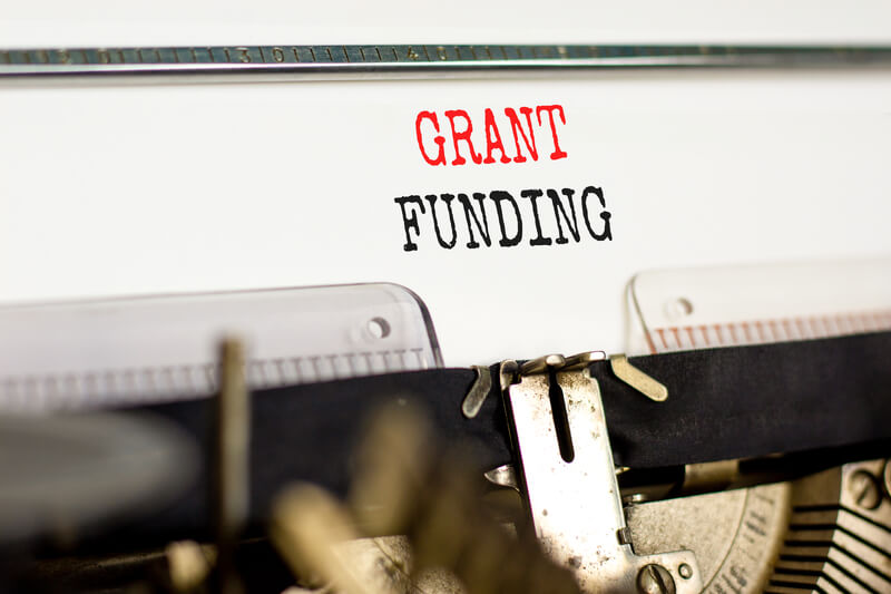 Grant funding symbol. Concept words Grant funding typed on old retro typewriter. Beautiful white background. Business and grant funding concept.