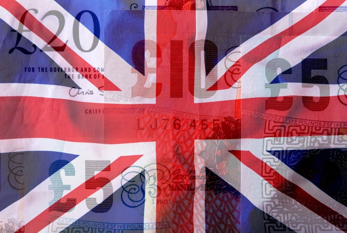 British Union Jack flag blowing in the wind. UK flag colorful and background pound banknotes.
