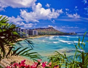 Waikiki Beach in Honolulu, Hawaii, famously featuring the Diamond Head volcanic crater in the background.