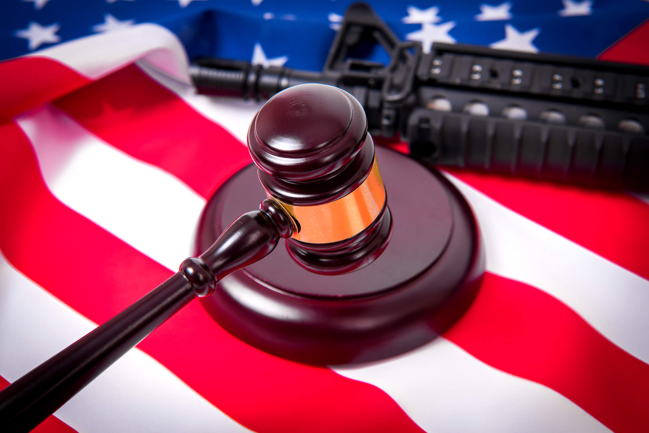 Gavel with gun on background of USA flag.