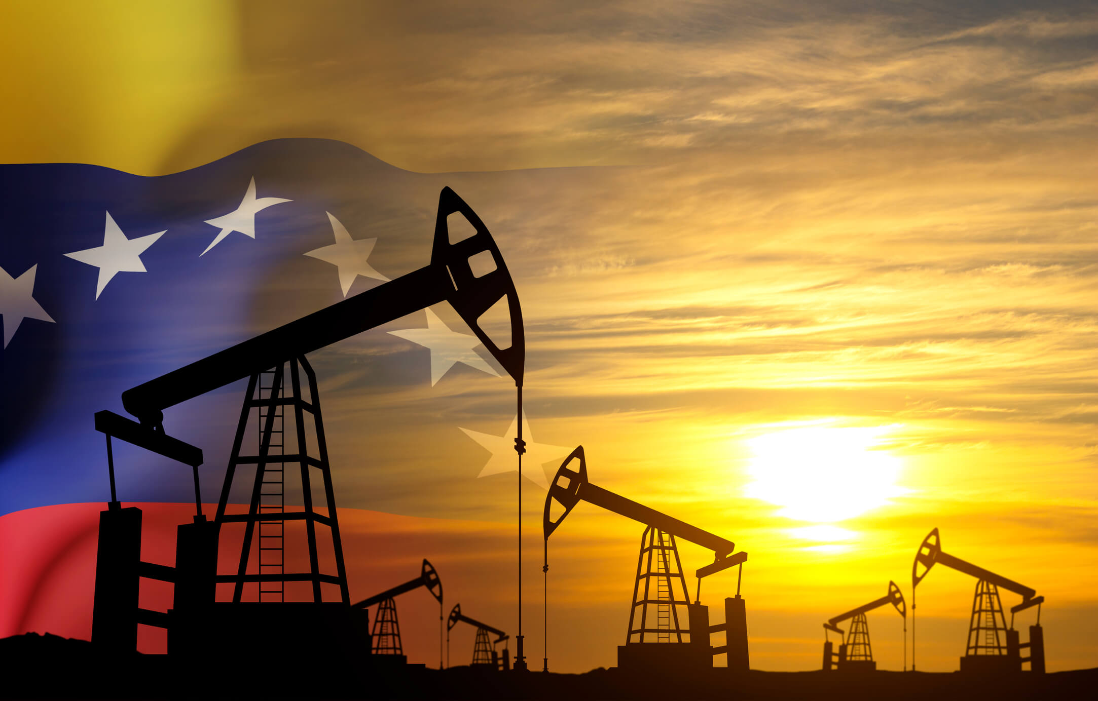 Silhouette of oil pumpjacks with Venezuela flag against the sunset. Oil industry concept
